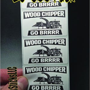 May include: A sheet of white stickers with black text and illustrations. Each sticker reads "WOOD CHIPPER" above a drawing of a wood chipper machine. Below the illustration is the text "GO BRRRR". The top of the sheet has the text "25-500 Pack".