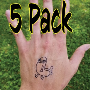 May include: A hand with a temporary tattoo of a cartoon character. The tattoo is black and white and depicts a stick figure with a large head and a long, thin body. The text "5 Pack" is written in black letters with a yellow outline on the hand's fingers.