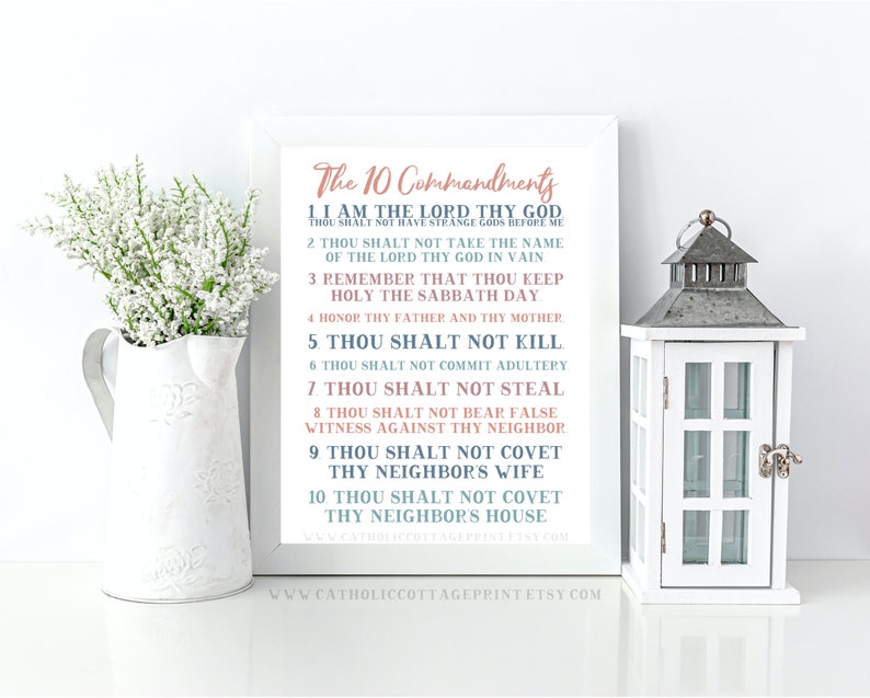May include: A printable wall art design featuring the Ten Commandments in a white frame with a light blue and pink color scheme. The text is in a decorative font and includes the phrase "Thou Shalt Not..." for each commandment.