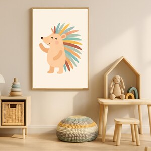 May include: A framed print of a cartoon hedgehog with a peach body and multi-coloured quills. The hedgehog is waving on a cream background. A colourful piece of art, ideal for a nursery or child's bedroom. The frame is a light wood colour.