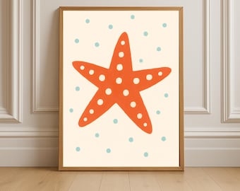 May include: A framed art print featuring a large orange starfish with white dots on a cream background. Small blue dots are scattered around the starfish. The artwork is in a wooden frame and is displayed on a wall.