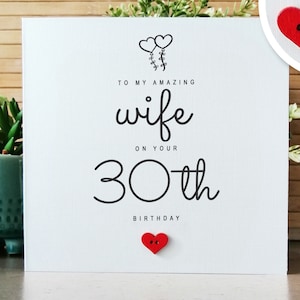 May include: White card with black text that reads "To my amazing wife on your 30th birthday". The card has two small red heart buttons attached to it.