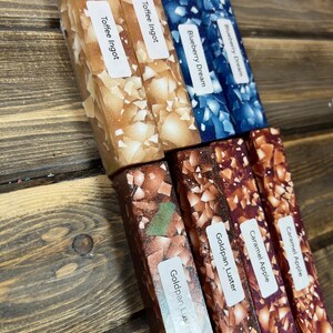 Pode incluir: Seis diferentes blocos de resina para artesanato, cada um com uma cor e um padrão únicos. Os blocos são etiquetados como "Toffee Ingot", "Blueberry Dream", "Goldpan Luster", "Caramel Apple", "Goldpan Luster", e "Caramel Apple".