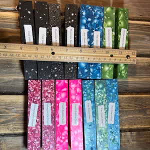 May include: A collection of 10 colorful resin blanks for crafting. The blanks are arranged in two rows, with the names of each blank printed below. The names include "Watermelon Rind", "Pre-dawn Sky", "Moonless Twinkle", "Coal Vein", "Fresh Bubble Gum", "Pomegranate Dream", and "Pre-Dawn Kiwi".