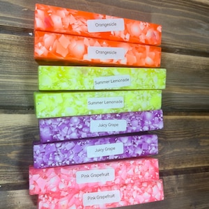 May include: Eight colorful resin blanks with white flecks. The blanks are labeled with the following names: Orangesicle, Summer Lemonade, Juicy Grape, and Pink Grapefruit.