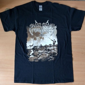 May include: Black t-shirt with a band logo and a faded image of a group of people standing on a rocky shore. The band's name is "Agalloch" and the logo is a stylized image of a serpent.