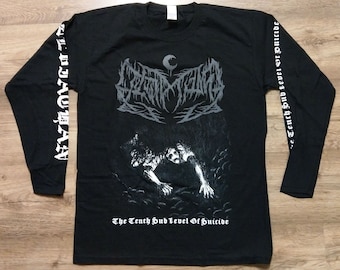 May include: Black long-sleeve shirt with a graphic design. The design features a stylized illustration and the text "The Tenth Sub Level Of Suicide". The sleeves have text in white. The shirt is displayed on a wooden surface.