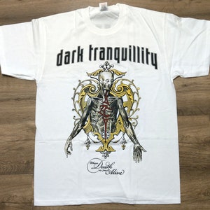 May include: White t-shirt with a black and gold graphic of a skeletal figure with the text "dark tranquillity" and "Where Death is Only Alive".