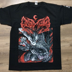 以下が含まれることがあります： 黒いTシャツに、赤い骨格の生き物と三日月が描かれた白と赤のグラフィックプリントが施されています。テキストは「DECAPITATED」です。