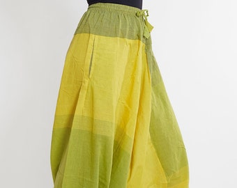 May include: A pair of yellow and green cotton pants with a drawstring waist. The pants are loose fitting and have a wide leg.