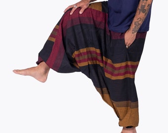 May include: Striped, loose-fitting pants with a black background and horizontal stripes in shades of red, brown, and gold. The pants are gathered at the ankles and have a relaxed fit.