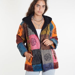 Può includere: Una giacca colorata in patchwork con chiusura a zip con cappuccio nero. La giacca presenta una varietà di motivi floreali in tonalità di arancione, rosa, blu e verde.