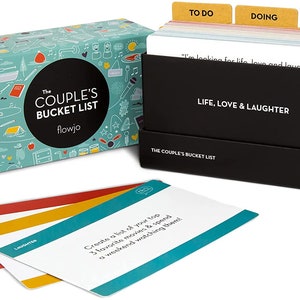 May include: A black box with a teal and white illustrated box lid. The box lid has the text "The Couple's Bucket List" and "flowjo". The box contains a set of cards with the text "Life, Love & Laughter" and "The Couple's Bucket List". The cards are divided into three sections: "To Do", "Doing", and "Done".