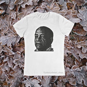 May include: White t-shirt featuring a black and white portrait. The graphic is a detailed illustration of a man's face. The text "Venkateshwari_shop" is printed at the bottom of the shirt.