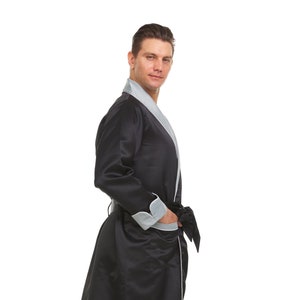 May include: A black satin robe with a grey satin trim and a self-tie belt. The robe has a shawl collar and long sleeves.
