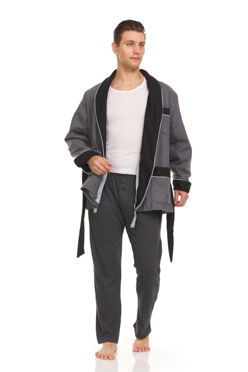 May include: A gray robe with a black satin collar and a white trim. The robe is tied at the waist with a black sash. The person is wearing gray pants.