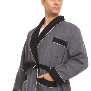 May include: A gray robe with black trim and a white piping detail. The robe has a shawl collar, a tie belt, and two pockets.
