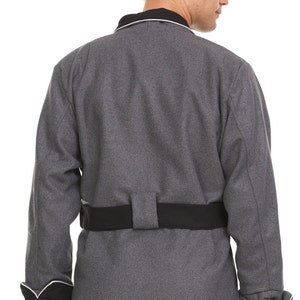 May include: A gray long-sleeved jacket with a black belt and white piping around the collar and cuffs.