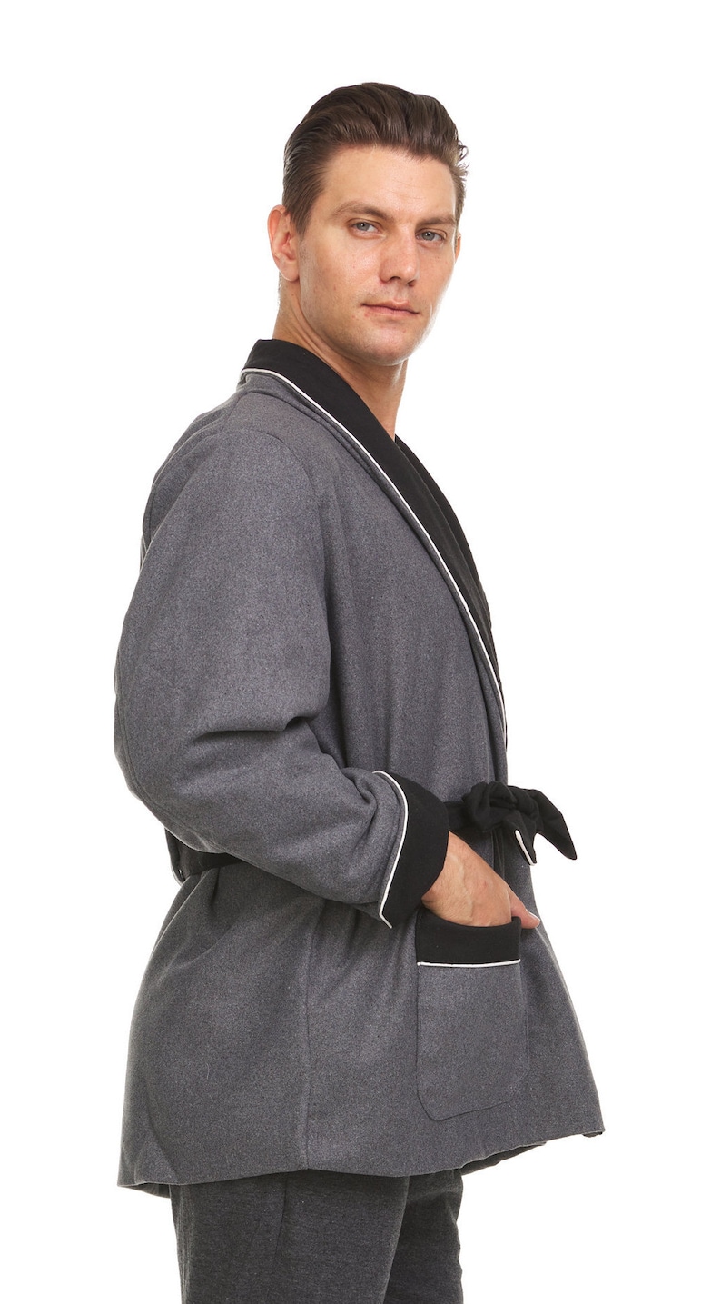 May include: A gray robe with black and white trim. The robe has a shawl collar, a tie belt, and a patch pocket on the left side.