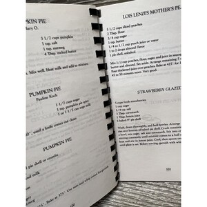 Puede incluir: Un libro de cocina vintage con recetas de pastel de calabaza, pastel de fresa glaseado y pastel de melocot&oacute;n. El libro de cocina tiene una cubierta marr&oacute;n con texto blanco y est&aacute; abierto en una p&aacute;gina con instrucciones para hacer pastel de fresa glaseado.