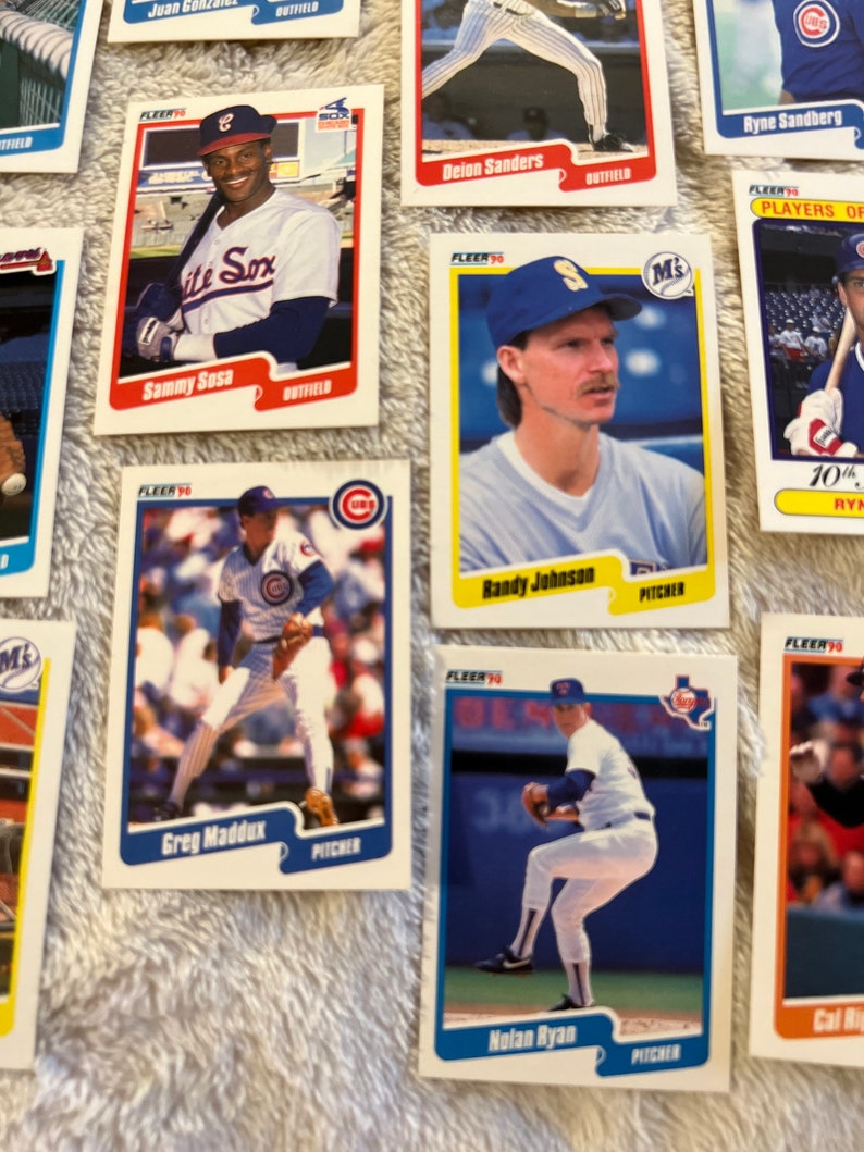 K&ouml;nnte beinhalten: Eine Sammlung von Baseball-Sammelkarten mit Spielern der Chicago Cubs und anderer Teams. Die Karten stammen aus der Fleer-Serie von 1990 und zeigen Spieler wie Sammy Sosa, Greg Maddux und Nolan Ryan.