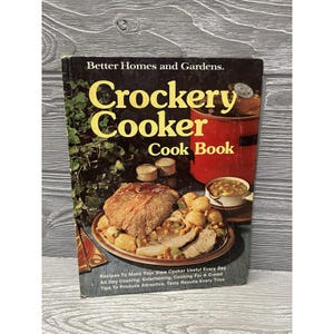 May include: Vintage "Crockery Cooker Cook Book" by Better Homes and Gardens. The cover features a red slow cooker, a plate of food, and text that reads "Recipes To Make Your Slow Cooker Useful Every Day".