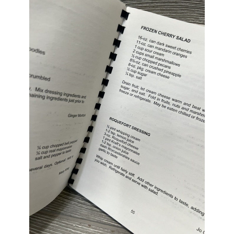 May include: A page from a vintage cookbook with recipes for Frozen Cherry Salad and Roquefort Dressing. The recipes list ingredients and instructions for preparing the dishes.