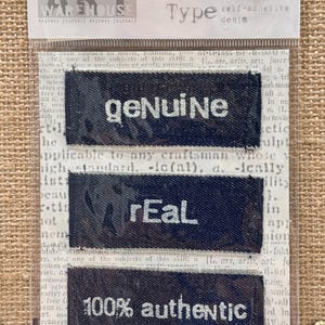 May include: Self-adhesive denim labels with the words "genuine", "real", and "100% authentic" printed in white. The labels are dark blue and come in a clear plastic package. The package also includes the text "Trademark Type".