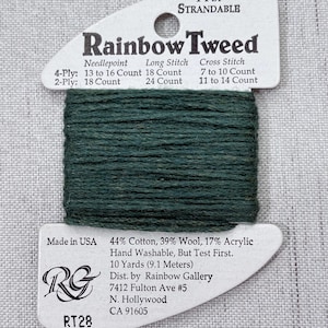 May include: A spool of dark green Rainbow Tweed yarn. The label reads "4-Ply Strandable" and includes needlepoint, long stitch, and cross stitch count information. The yarn is made in the USA and is 44% cotton, 39% wool, and 17% acrylic.