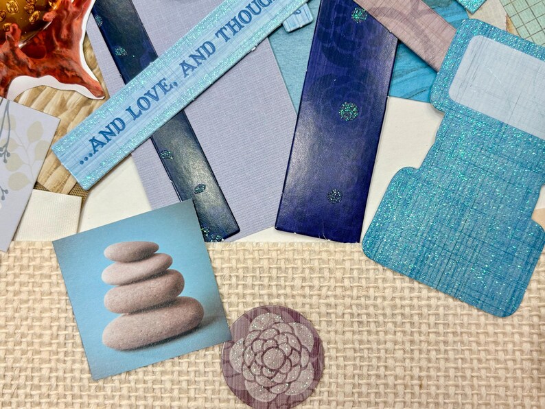 May include: A collage featuring various paper elements in shades of blue, gray, and beige. Includes a square image of stacked stones, a floral design, and a strip of paper with the text "...AND LOVE, AND THOUGHT".