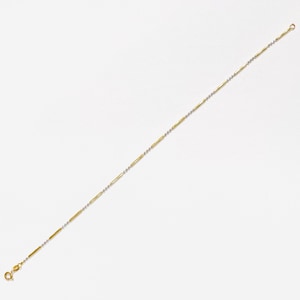 May include: A delicate gold and silver chain bracelet. The bracelet features alternating segments of gold and silver, creating a linear pattern. The clasp and connecting ring are gold. The bracelet is displayed against a white background.