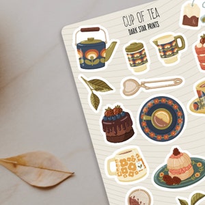May include: A set of 10 retro-style stickers featuring a teacup, teapot, cake, and other tea-themed illustrations. The stickers are white with a black outline and feature a dark star print design. The text "CUP OF TEA DARK STAR PRINTS" is at the top of the image.