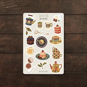 May include: A sheet of stickers featuring a variety of tea-themed illustrations, including teapots, cups, tea bags, cakes, and tea leaves. The stickers are in a retro style with colourful patterns and designs. The text "CUP OF TEA DARK STAR PRINTS" is at the top of the sheet.