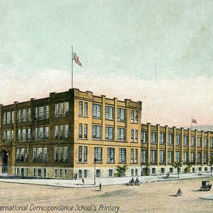May include: A vintage postcard depicting a large, yellow brick building with multiple windows. The building is labeled "Scranton, Pa., International Correspondence School's Printlery".