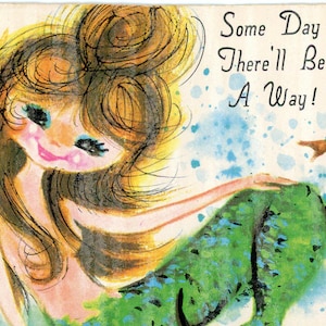 May include: A vintage-style illustration of a mermaid with long brown hair and a green tail, positioned next to a brown seahorse and pink coral. The text "Some Day There'll Be A Way!" is printed in black script in the upper right corner of the image.