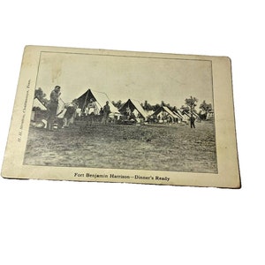 May include: Black and white photograph of a military camp with tents and soldiers. The caption reads "Fort Benjamin Harrison - Dinner's Ready".