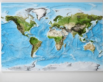 May include: A blue and green world map with raised topography, showing the continents and oceans. The map is framed and hanging on a white wall above a bed with grey bedding.