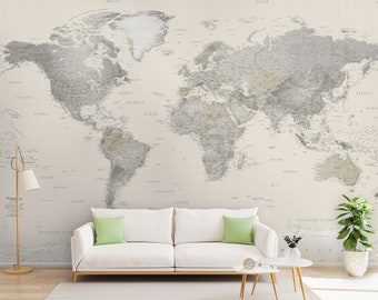 Può includere: Un divano bianco con un cuscino verde si trova di fronte a un muro con una carta da parati di mappa del mondo vintage. La mappa è in tonalità di grigio e marrone con dettagli oceanici blu. Un tavolino con un piano rotondo si trova a destra del divano. Una pianta in vaso si trova a destra dell'immagine.
