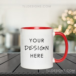 May include: White ceramic mug with a red rim and handle. The mug has the text "YOUR DESIGN HERE" printed on the front.