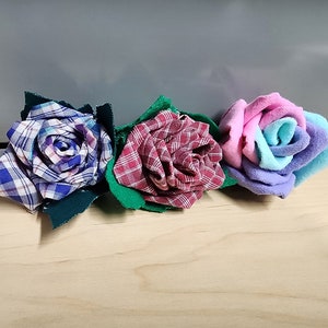 May include: Three fabric roses, one blue and white plaid, one red and white plaid, and one multi-colored.