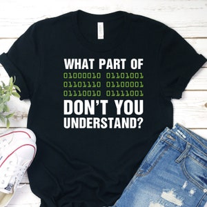 Peut inclure: T-shirt noir avec le texte "WHAT PART OF 01000010 01101001 01101110 01100001 01110010 01111001 DON'T YOU UNDERSTAND?" en vert.