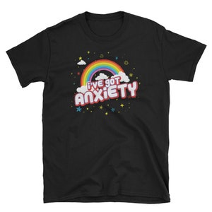 Puede incluir: Camiseta negra con un arco&iacute;ris y el texto "I've got anxiety" en letras rosas y blancas.