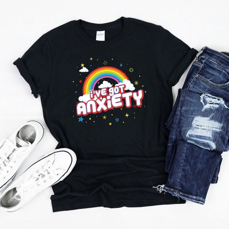 Puede incluir: Camiseta negra con un arco&iacute;ris y el texto "I've got anxiety" en letras rojas.