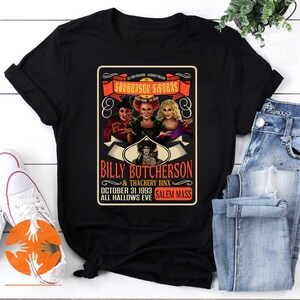 Pode incluir: Camiseta preta com um design de pôster vintage com as irmãs Sanderson do filme Hocus Pocus. O pôster diz "Sanderson Sisters" e "Billy Butcherson & Thackery Binx" com a data "31 de outubro de 1993" e "Salem Mass All Hallows Eve."