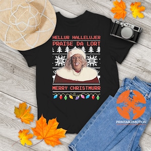 Könnte beinhalten: Schwarzes T-Shirt mit einem Weihnachtsmotiv, das eine Frau in einem Weihnachtsmann-Hut und einem rot-weißen Outfit zeigt. Der Text auf dem Shirt lautet "Hellur Hallelujer Praise Da Lort Merry Christmurr".