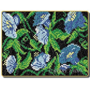 May include: A close-up of a blue and green floral embroidery design on a black background. The design features several blue flowers with green leaves and stems.