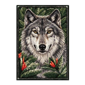 May include: A rectangular rug featuring a detailed portrait of a wolf. The wolf has gray and white fur, yellow eyes, and a black nose. Green foliage and red flowers surround the wolf, set against a black border.