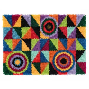 May include: A rectangular, colorful rug with a geometric design. The rug features triangles and circles in various colors, including red, orange, yellow, green, blue, purple, and black. The rug's dimensions are not visible in the image.