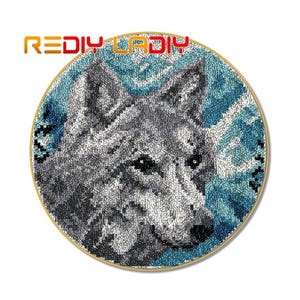 May include: A round needlepoint embroidery of a gray wolf with a blue and white background. The wolf's face is close-up and the background is a swirling pattern.