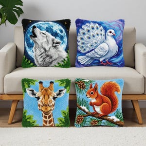 May include: Four decorative throw pillows with animal designs. The pillows feature a howling wolf against a moon, a white peacock, a giraffe, and a squirrel on a branch. Each pillow has a textured, embroidered appearance.